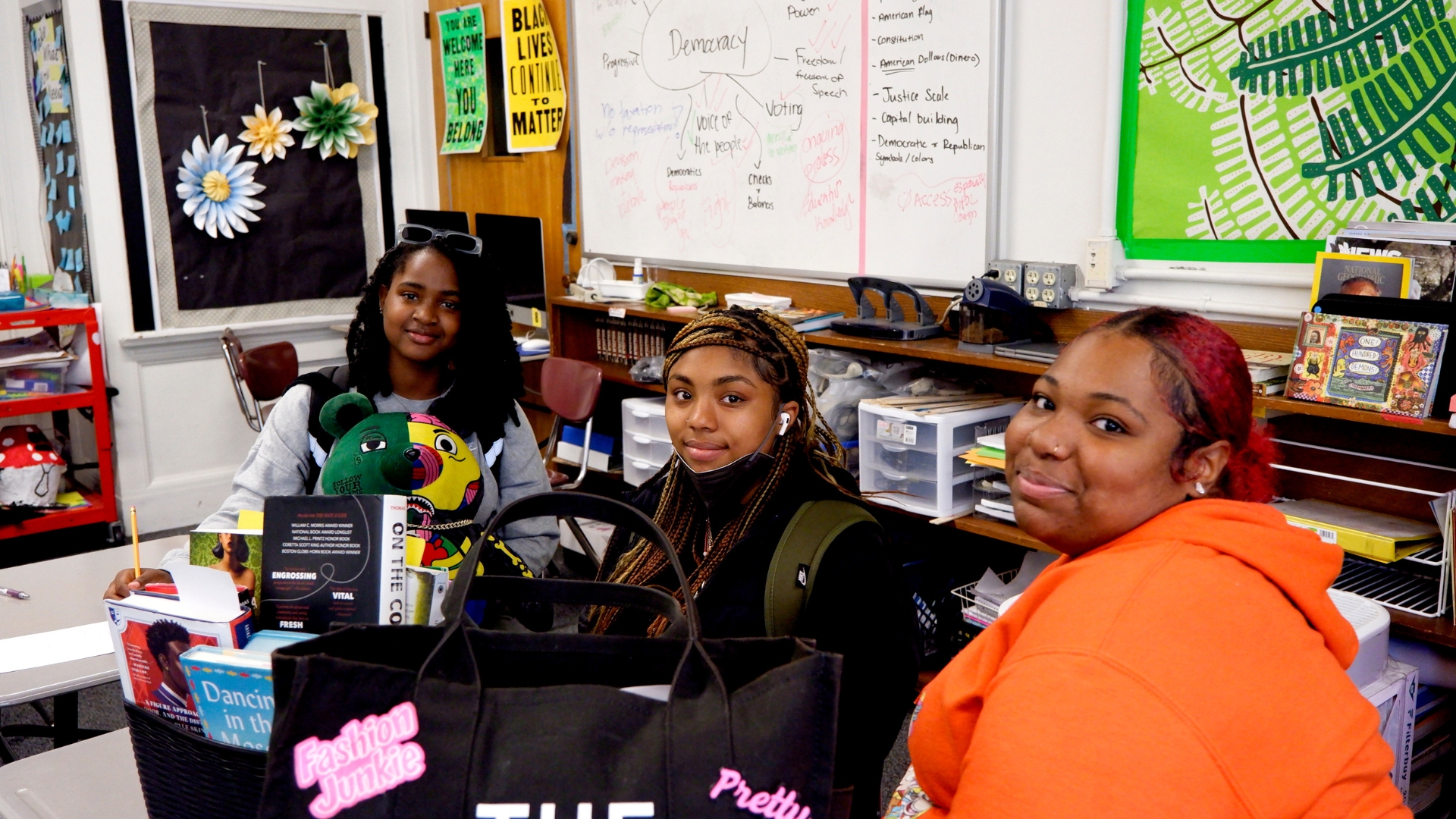 Students hold bags filled with books