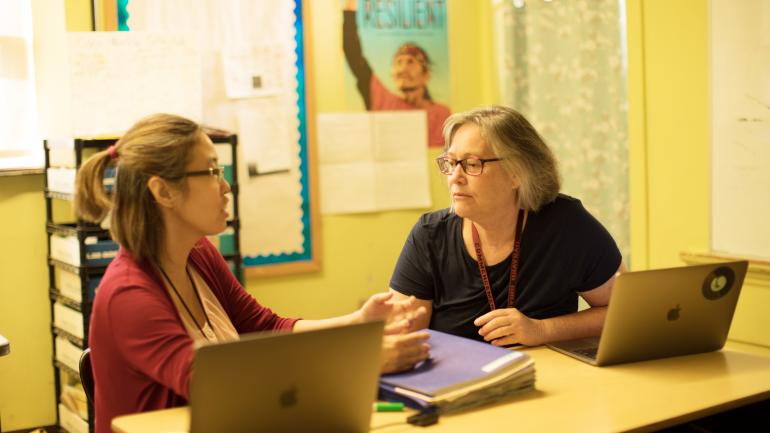 teachers discussing over a laptop