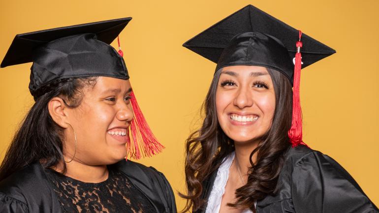 two female graduates smiling
