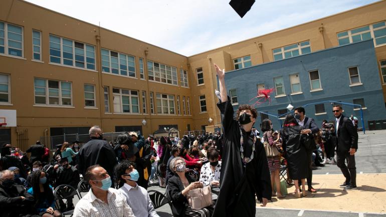 graduate throws cap in the air