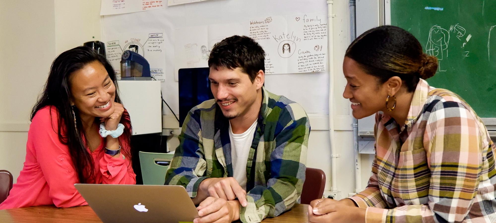 three teachers collaborating around a laptop