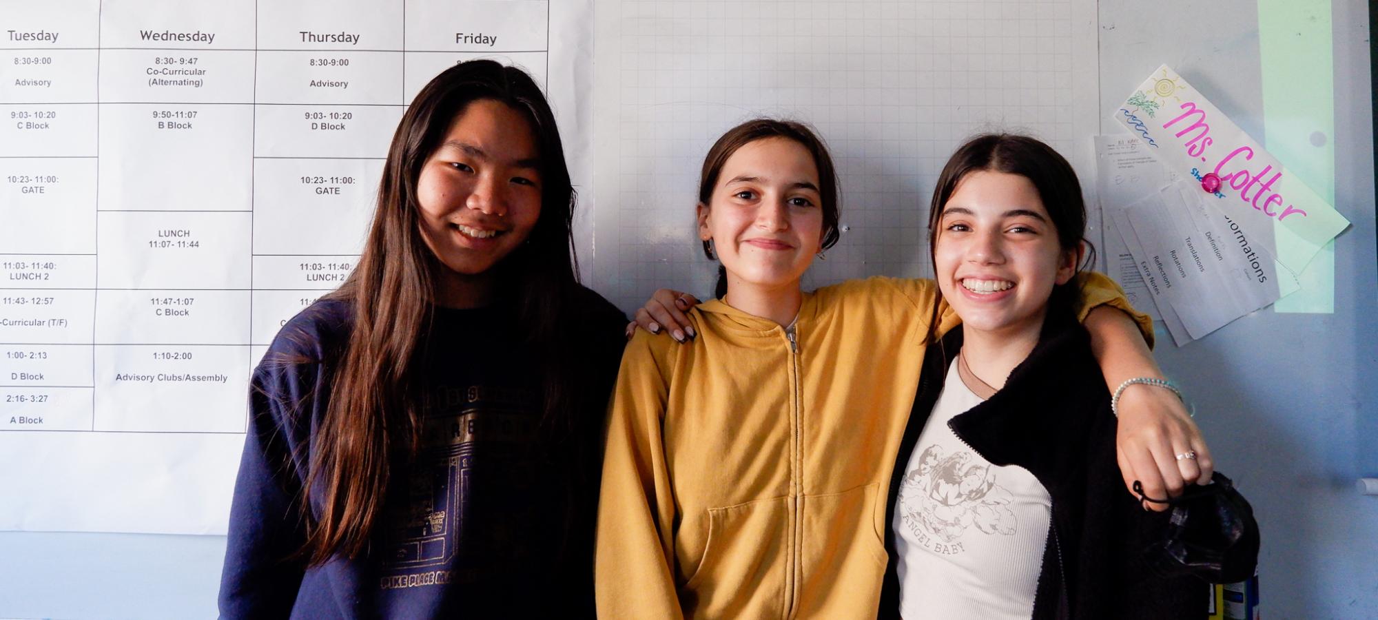 three girls pose for camera