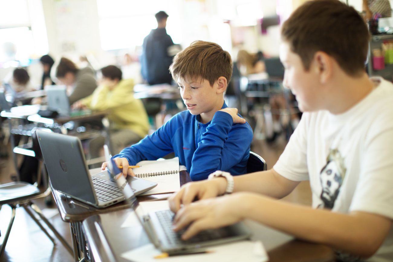 two male students working on a laptop