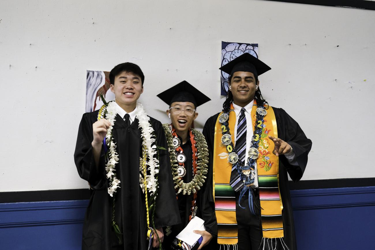 Three male students celebrating graduation
