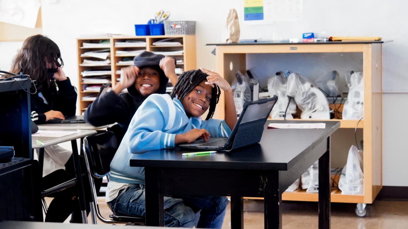 A boy smiles in class