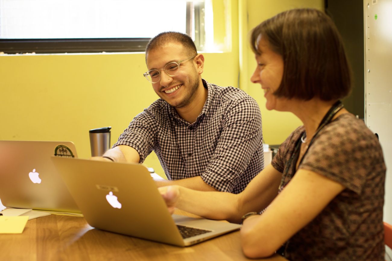 Two people collaborating with laptops