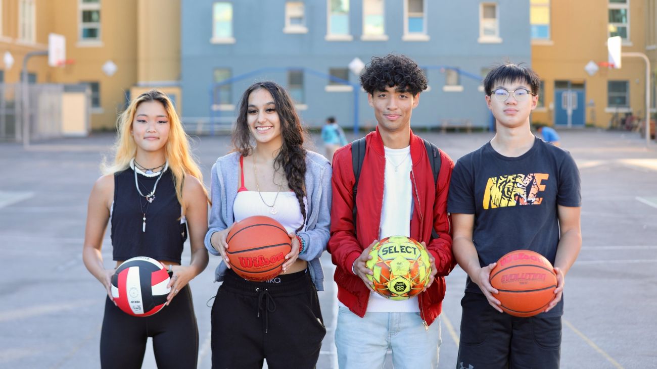 Four students holding basketballs